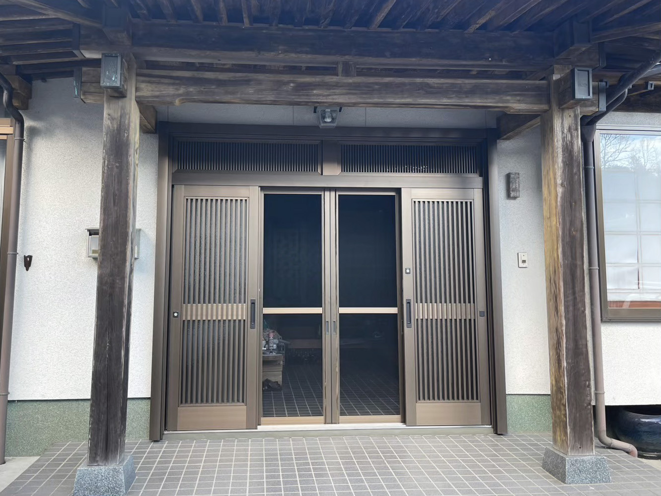 取替工事で綺麗になった4枚建の玄関引戸（開けた状態・網戸）